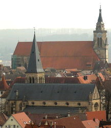 Gotik: Die spätgotische Stiftskirche wurde 1470-83 anstelle zweier romanischer Vorgängerkirchen unter Graf Eberhard im Bart errichtet. Im Bild oben die Stiftskirche von Norden, davor die neugotische Johanneskirche (1878)